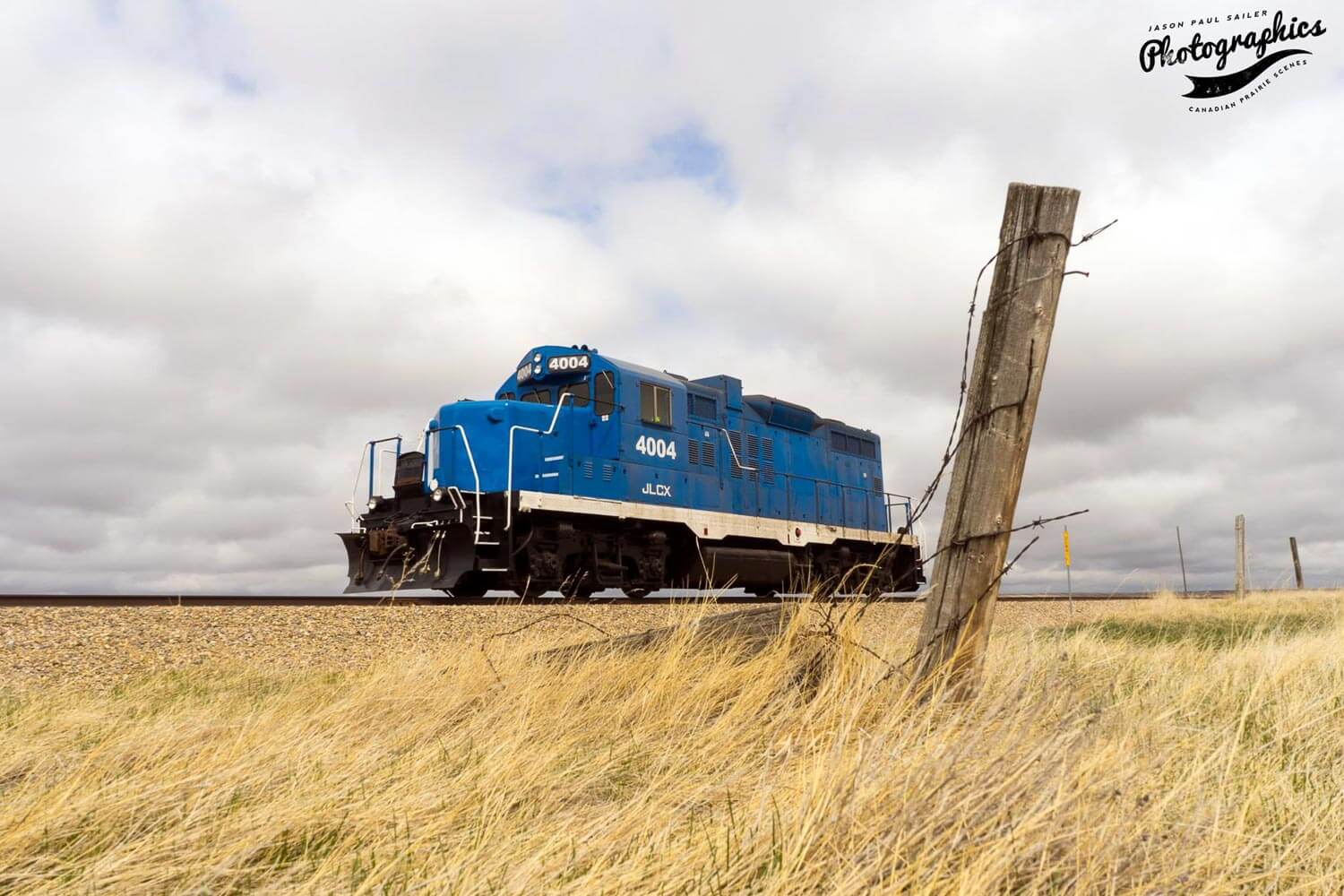 Blue train engine driving through the prairies